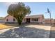 Charming single-story home featuring a spacious driveway, mature tree and desert landscaping at 14408 N 35Th Ave, Phoenix, AZ 85053