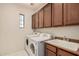 Laundry room with white washer and dryer, storage cabinets, and a utility sink at 1481 E Lark St, Gilbert, AZ 85297