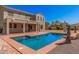 Backyard pool with umbrellas, a clear blue sky and a view of the two-story home at 1481 E Lark St, Gilbert, AZ 85297