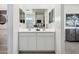 Bright bathroom featuring double sinks, white cabinets, and a large mirror in the middle at 1503 S 239Th Dr, Buckeye, AZ 85326