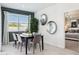 Elegant dining area with a modern table, seating for six, and large windows providing natural light at 1503 S 239Th Dr, Buckeye, AZ 85326