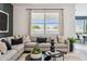 Cozy living room featuring a comfortable sectional sofa, decorative pillows, and a view of the outdoors at 1503 S 239Th Dr, Buckeye, AZ 85326