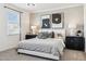 This main bedroom features a large bed, eye-catching lamps, and monochromatic artwork above the headboard at 1503 S 239Th Dr, Buckeye, AZ 85326