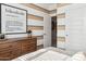 Stylish bedroom featuring striped accent wall, a modern dresser, and an open doorway at 1531 S 239Th Dr, Buckeye, AZ 85326