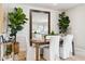 Elegant dining room featuring a wooden table, white chairs, and a large mirror on a shiplap wall at 1531 S 239Th Dr, Buckeye, AZ 85326