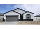 Charming single-story home featuring a gray garage door, dark accents, and a well-maintained, low maintenance front yard at 1531 S 239Th Dr, Buckeye, AZ 85326