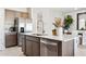 Modern kitchen island with stainless steel dishwasher and sink, quartz countertop, and ample storage at 1531 S 239Th Dr, Buckeye, AZ 85326