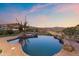 Inviting backyard pool and spa featuring natural rock accents and scenic desert views at 15504 E Firerock Country Club Dr, Fountain Hills, AZ 85268