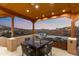 Enjoy al fresco dining with this outdoor kitchen and dining area with stunning mountain views at sunset at 15504 E Firerock Country Club Dr, Fountain Hills, AZ 85268