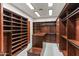 Custom walk-in closet with dark wood shelving and ample storage space at 15504 E Firerock Country Club Dr, Fountain Hills, AZ 85268