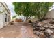 Picturesque backyard with paver walkway, mature trees, and natural rock accents at 15602 N 19Th St, Phoenix, AZ 85022