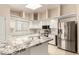 Bright kitchen featuring a marble island, white cabinets, stainless steel appliances, and tile floors at 15602 N 19Th St, Phoenix, AZ 85022