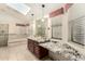 Bright bathroom featuring double sink vanity with granite counters, soaking tub, and glass shower at 15602 N 19Th St, Phoenix, AZ 85022