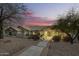 Charming home exterior featuring a well-manicured lawn, a paved walkway, and decorative lighting at twilight at 15747 E Greystone Dr, Fountain Hills, AZ 85268