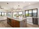 Bright kitchen featuring a large island with granite countertop, modern lighting, and stainless steel appliances at 15747 E Greystone Dr, Fountain Hills, AZ 85268