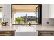 Bright kitchen sink with marble countertops, herringbone backsplash, and view of desert hillside at 15747 E Greystone Dr, Fountain Hills, AZ 85268