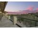 A covered patio with clear glass railing showcases a panoramic sunset view overlooking the mountains at 15747 E Greystone Dr, Fountain Hills, AZ 85268