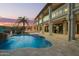 Back of luxury estate with a backyard waterfall pool, covered patio, and second story balcony at 15747 E Greystone Dr, Fountain Hills, AZ 85268