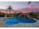 Private pool with a stone waterfall, inset spa, and towering palm trees; a desert oasis at 15747 E Greystone Dr, Fountain Hills, AZ 85268