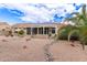 Desert landscaped backyard with a covered patio, providing shade and style at 16019 W Heritage Dr, Sun City West, AZ 85375