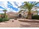 Well-maintained front yard with desert landscaping, mature palm trees, and a cozy seating area at 16019 W Heritage Dr, Sun City West, AZ 85375