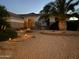 Inviting front yard featuring a desert landscape, palm tree, stone walkway, and warm lighting accents at 16019 W Heritage Dr, Sun City West, AZ 85375