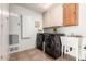 Functional laundry room with washer, dryer, sink, and built-in cabinets at 16019 W Heritage Dr, Sun City West, AZ 85375