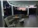 Cozy covered patio with string lights, tile flooring, and comfortable seating area at twilight at 16019 W Heritage Dr, Sun City West, AZ 85375