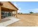 Covered patio with outdoor seating overlooks the spacious, low-maintenance desert landscaping at 17530 W Oberlin Way, Surprise, AZ 85387