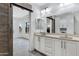 Spacious bathroom featuring a double vanity, modern mirrors, and a barn door leading to closet at 17530 W Oberlin Way, Surprise, AZ 85387