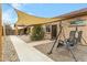 Inviting courtyard with seating, sun sail, and a charming swing, perfect for relaxing outdoors at 17530 W Oberlin Way, Surprise, AZ 85387