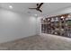 Bright living room featuring neutral walls, a ceiling fan, and a large decorative bookshelf at 17530 W Oberlin Way, Surprise, AZ 85387