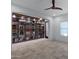 Bright living room featuring neutral walls, a ceiling fan, and a large decorative bookshelf at 17530 W Oberlin Way, Surprise, AZ 85387