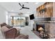 Comfortable living room with a stone fireplace, wood paneling, and sliding doors to the backyard at 17530 W Oberlin Way, Surprise, AZ 85387