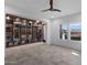 Bright living room featuring neutral walls, a ceiling fan, a decorative bookshelf, and abundant natural light at 17530 W Oberlin Way, Surprise, AZ 85387