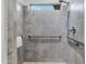 A modern shower with gray tile, a hand rail, and a clear window at 17530 W Oberlin Way, Surprise, AZ 85387