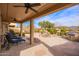 Expansive covered patio featuring a stone fireplace, outdoor kitchen, water feature, and views of the landscaped yard at 17846 W Fairview St, Goodyear, AZ 85338