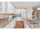 Bright kitchen features white cabinetry, granite countertops, stainless steel appliances, and hardwood floors at 17846 W Fairview St, Goodyear, AZ 85338