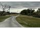 Scenic neighborhood walking path offers a peaceful retreat with mature trees and lush grass and cloudy sky at 17846 W Fairview St, Goodyear, AZ 85338