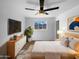 Stylishly decorated bedroom with ceiling fan, modern furniture and decor, and a window with a view of the neighborhood at 1801 W 5Th Pl, Mesa, AZ 85201