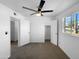 Bedroom featuring neutral carpet, ceiling fan, window overlooking the neighborhood, and access to a closet at 1801 W 5Th Pl, Mesa, AZ 85201