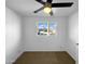 Simple bedroom featuring neutral carpet, a ceiling fan, and a window overlooking the neighborhood at 1801 W 5Th Pl, Mesa, AZ 85201