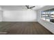 Bright living room featuring new carpet, a ceiling fan, and a large window that looks out to the neighborhood at 1801 W 5Th Pl, Mesa, AZ 85201