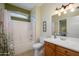 Bathroom with a shower-tub combo with flower-patterned shower curtain, wood vanity, and toilet at 18701 N Diamond Dr, Surprise, AZ 85374