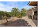 Private backyard featuring desert landscaping, palm trees, block wall fence, and a built-in grill at 1873 Leisure World --, Mesa, AZ 85206