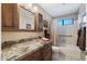 Bathroom with granite countertop, wooden cabinets, and a shower/tub combo behind a curtain at 1873 Leisure World --, Mesa, AZ 85206