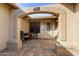 Inviting covered front porch with an arched entryway, brick pavers, and seating area at 1873 Leisure World --, Mesa, AZ 85206