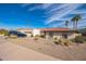 Attractive home exterior with a tile roof, desert landscaping, and mature palm trees at 1908 E Beck Ln, Phoenix, AZ 85022