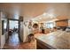 Open-concept kitchen area with custom counter, brick oven, and terracotta tile flooring at 1908 E Beck Ln, Phoenix, AZ 85022