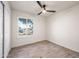 Cozy bedroom features a ceiling fan, wood-look tile floors and a window with views of the neighborhood at 1911 W Kimberly Way, Phoenix, AZ 85027